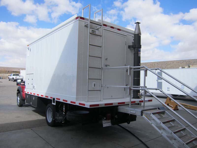 A white maneuverable trailer with metal stairs