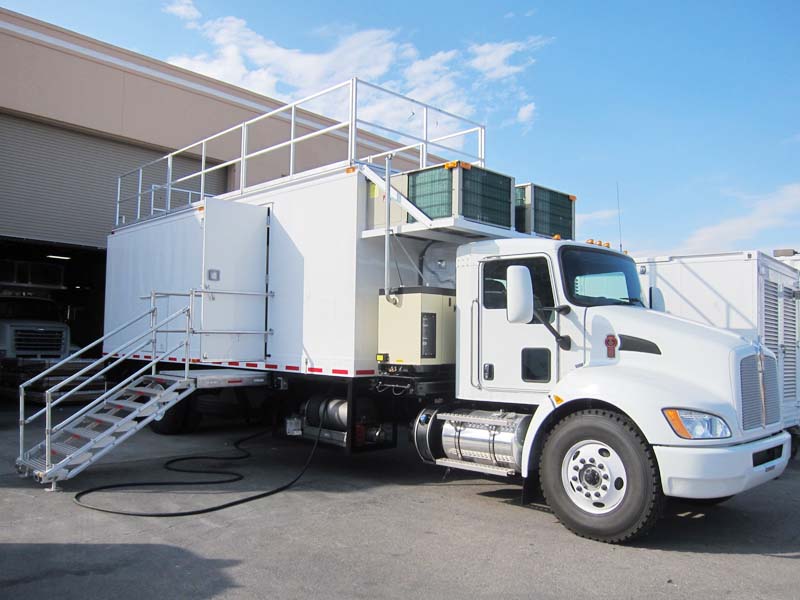 A white truck with a metal staircase and a roof deck