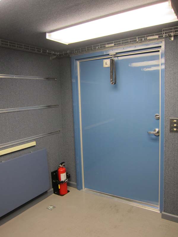 A fire extinguisher near a blue metal door