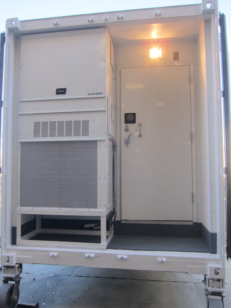 A white transportable container with an outdoor lamp