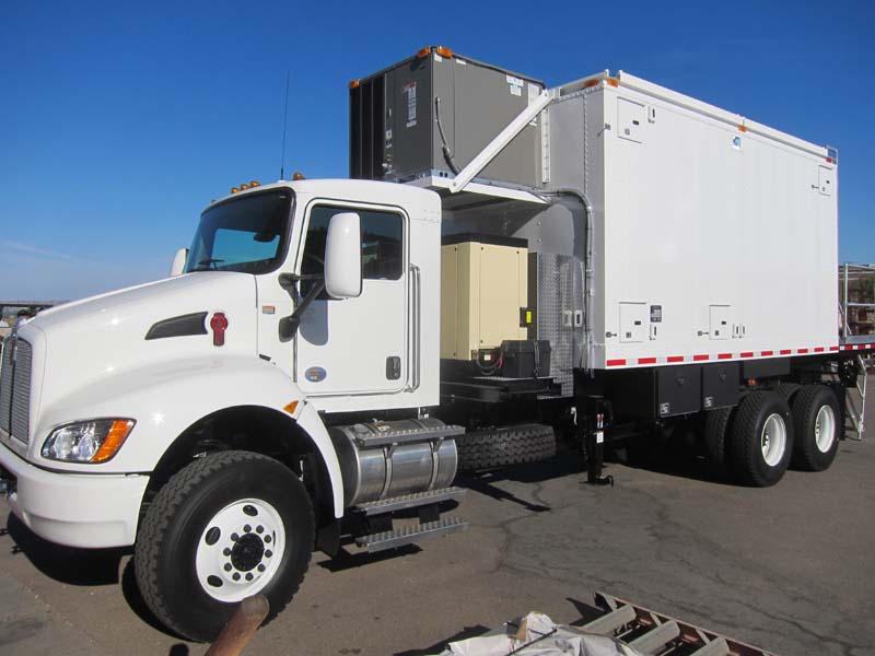 A midsize white truck with extra machines