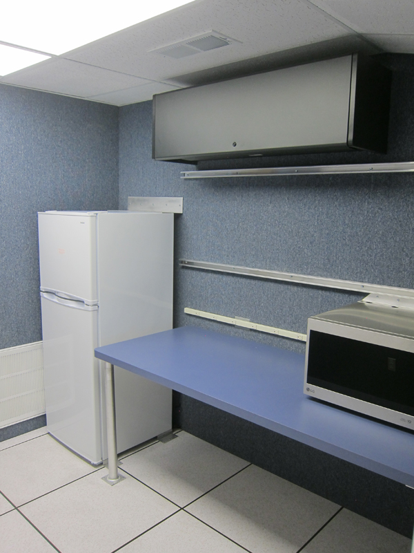 A white refrigerator, an oven, and a black shelf