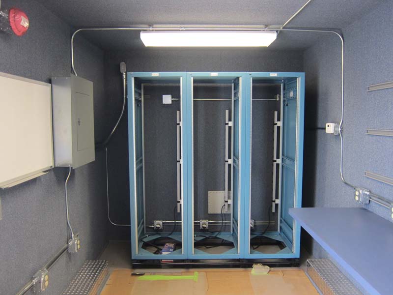 Three blue cabinets inside the mobile shelter